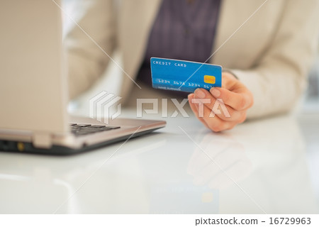 Closeup on business woman credit card using laptop Closeup on business woman credit card using laptop 16729963
