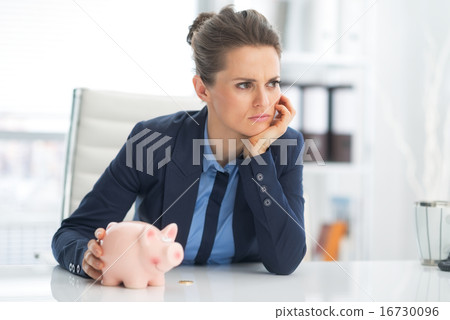 Thoughtful business woman piggy bank with 16730096
