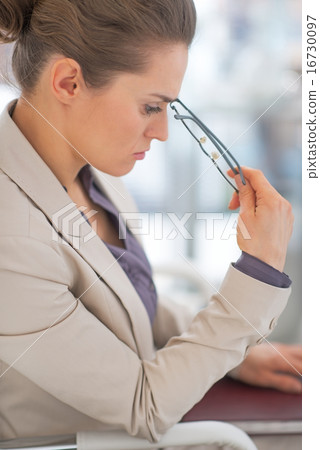 Portrait of thoughtful business woman with eyeglasses in office 16730097