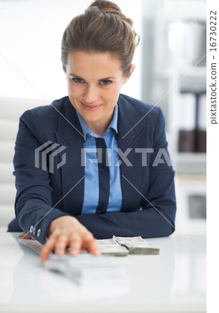 Business woman giving money packs 16730222