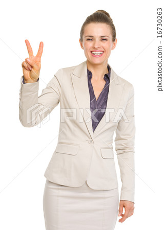 Smiling business woman showing victory gesture Smiling business woman showing victory gesture 16730263