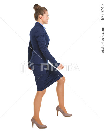 Full length portrait of happy business woman climbing the stairs Full length portrait of happy business woman climbing the stairs 16730749