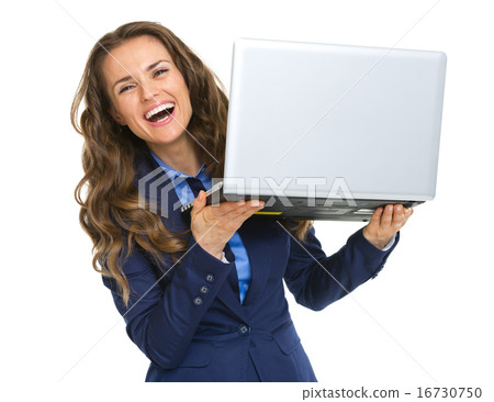 Smiling business woman looking out from laptop Smiling business woman looking out from laptop 16730750