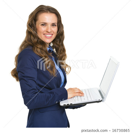 Smiling business woman working on laptop 16730865