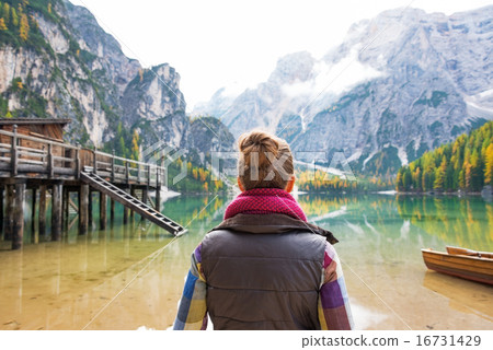 Young woman on lake braies in south tyrol, italy. rear view 16731429