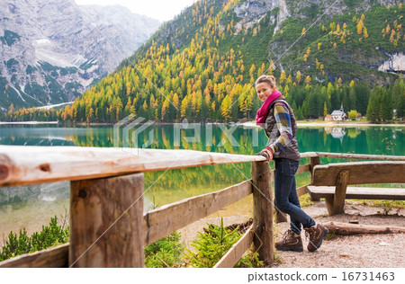 Woman hiker rests on a wooden railing, facing Lake Bries 16731463