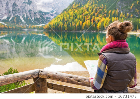 Young woman with map on lake braies in south tyrol, italy. rear 16731475