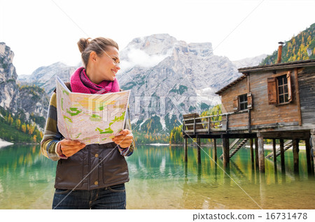 Woman at Lake Bries holding an open map and smiling Woman at Lake Bries holding an open map and smiling 16731478
