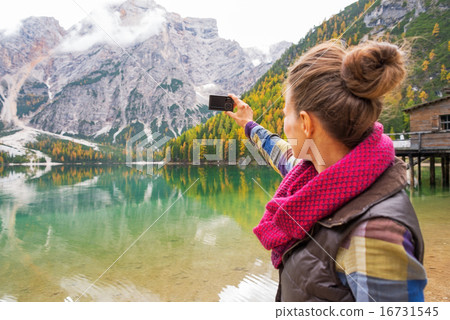 Young woman taking photo on lake braies in south tyrol, italy. r 16731545
