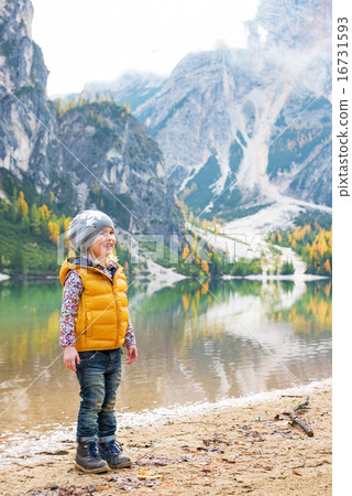 Full length portrait of child on lake braies in south tyrol, ita 16731593