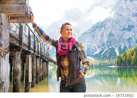 Happy young woman on lake braies in south tyrol, italy 16731602