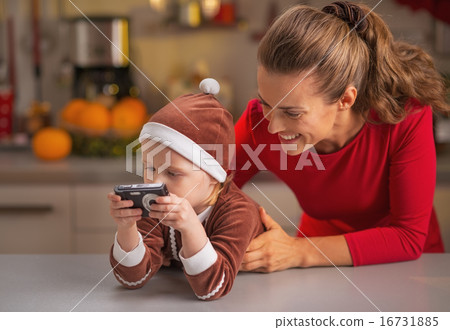 Happy mother and baby looking photos in camera Happy mother and baby looking photos in camera 16731885
