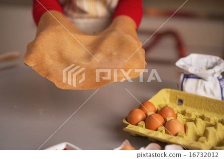 Closeup on dough in hand of young housewife Closeup on dough in hand of young housewife 16732012