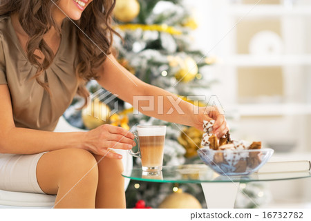 Closeup on young woman enjoying latte macchiato and candy 16732782