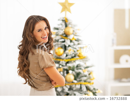 Portrait of smiling young woman near christmas tree Portrait of smiling young woman near christmas tree 16732888