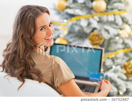 Portrait of smiling young woman with credit card and laptop in f Portrait of smiling young woman with credit card and laptop in f 16732987