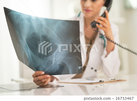 Closeup on medical doctor woman looking on fluorography and talk 16733467