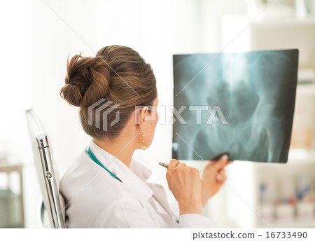 Medical doctor woman looking on fluorography. rear view 16733490