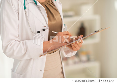 Closeup on medical doctor woman writing in clipboard Closeup on medical doctor woman writing in clipboard 16733528