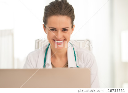 Portrait of smiling medical doctor woman using laptop Portrait of smiling medical doctor woman using laptop 16733531