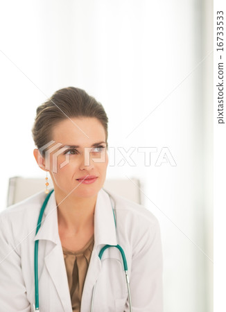 Medical doctor woman sitting in office and looking on copy space Medical doctor woman sitting in office and looking on copy space 16733533