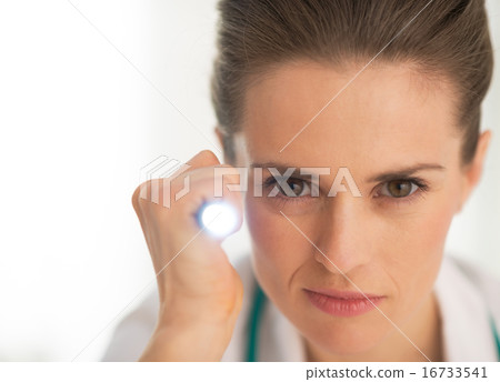Portrait of doctor woman using flashlight Portrait of doctor woman using flashlight 16733541