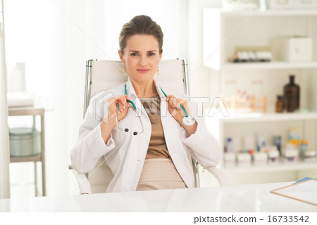 Portrait of happy medical doctor woman sitting in office Portrait of happy medical doctor woman sitting in office 16733542