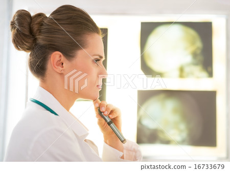 Portrait of thoughtful medical doctor woman in front of tomograp 16733679