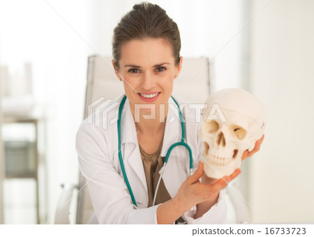 Portrait of happy medical doctor woman showing human skull Portrait of happy medical doctor woman showing human skull 16733723