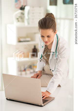Medical doctor woman working on laptop in office 16733734