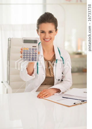 Happy medical doctor woman showing calculator Happy medical doctor woman showing calculator 16733738