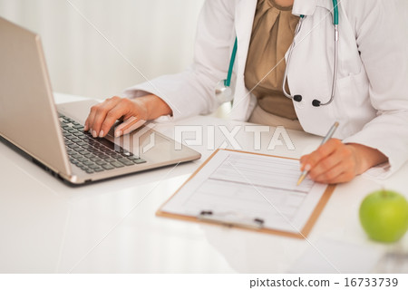 Closeup on doctor woman working on laptop in office Closeup on doctor woman working on laptop in office 16733739