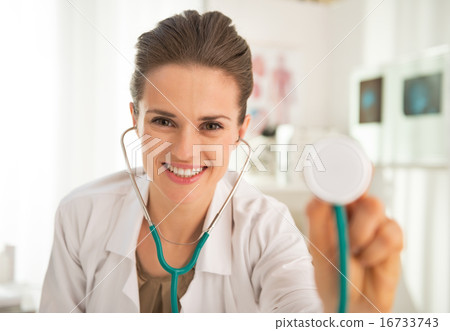 Happy medical doctor woman stretching stethoscope in camera Happy medical doctor woman stretching stethoscope in camera 16733743