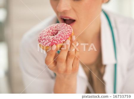 Closeup on doctor woman biting donut Closeup on doctor woman biting donut 16733759