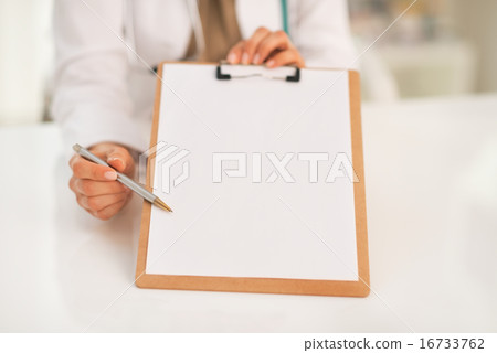 Closeup on happy medical doctor woman pointing in clipboard Closeup on happy medical doctor woman pointing in clipboard 16733762