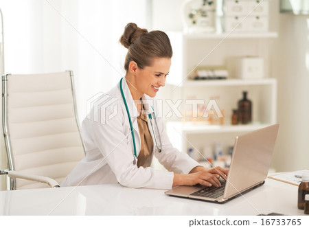 Doctor woman working on laptop in office 16733765