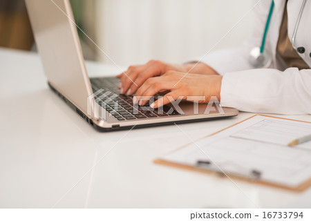 Closeup on medical doctor woman working on laptop Closeup on medical doctor woman working on laptop 16733794