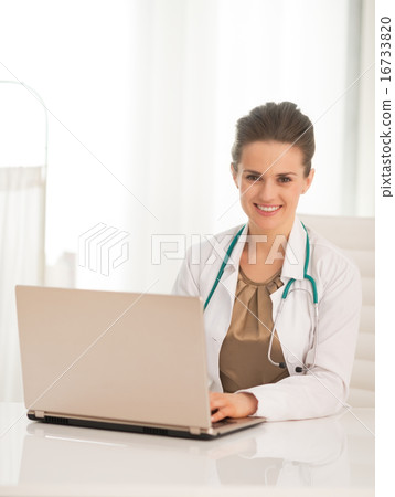 Portrait of happy medical doctor woman using laptop Portrait of happy medical doctor woman using laptop 16733820