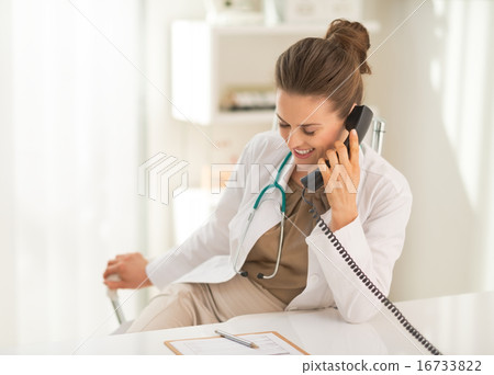 Smiling medical doctor woman talking phone Smiling medical doctor woman talking phone 16733822