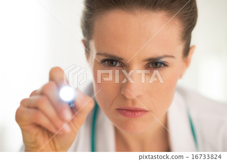Portrait of medical doctor woman examining using flashlight Portrait of medical doctor woman examining using flashlight 16733824