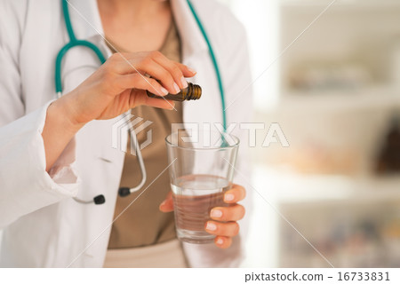 Closeup on medical doctor woman calmative into glass Closeup on medical doctor woman calmative into glass 16733831