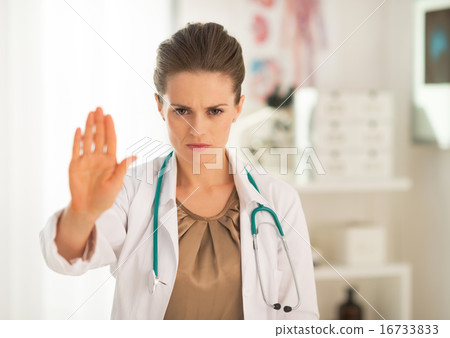 Portrait of serious medical doctor woman showing stop gesture 16733833