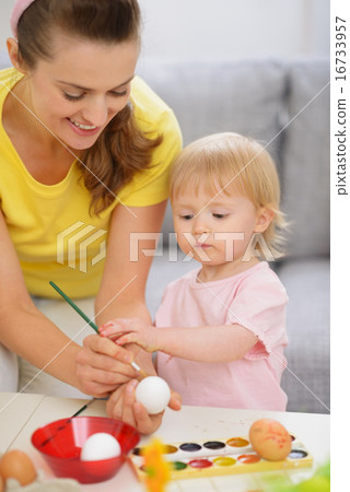 Happy mother and baby painting on Easter eggs Happy mother and baby painting on Easter eggs 16733957
