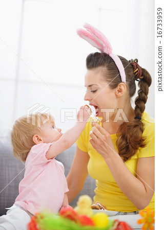 Baby feeding mother Easter biscuits Baby feeding mother Easter biscuits 16733959
