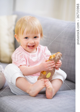 Happy baby eating Easter rabbit cookie 16733968