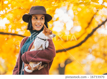 Portrait of happy young woman with dog outdoors in autumn lookin Portrait of happy young woman with dog outdoors in autumn lookin 16733970