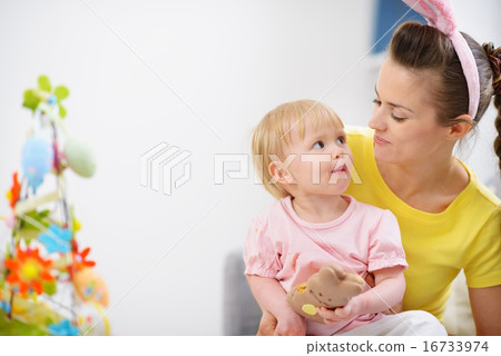 Mother and baby eating chocolate Easter rabbit cookie Mother and baby eating chocolate Easter rabbit cookie 16733974