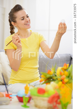 Young woman preparing for Easter and drawing on egg Young woman preparing for Easter and drawing on egg 16733975