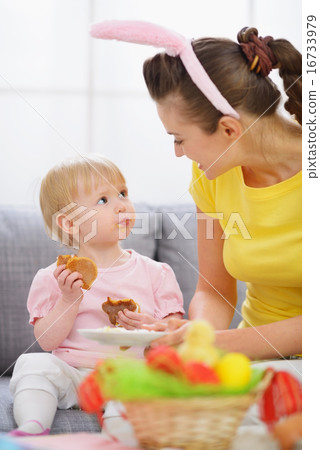 Mother with baby eating Easter cookies 16733979