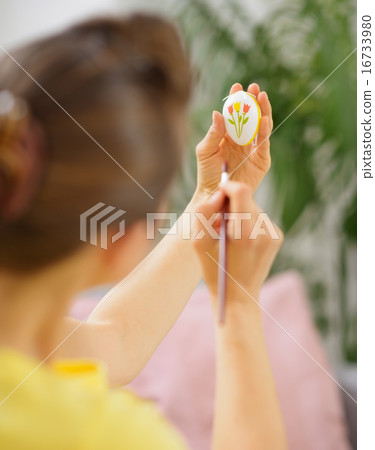 Woman drawing on Easter egg 16733980